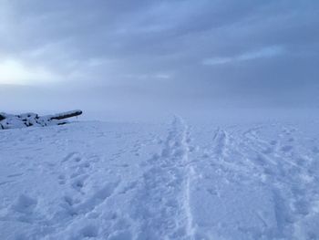 Scenic view of snow covered field against sky