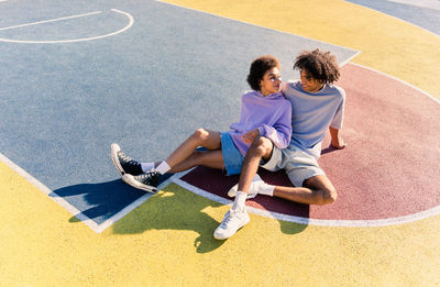 Side view of young woman exercising on field