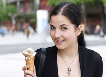 Close-up portrait of beautiful young woman holding ice cream cone
