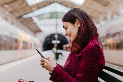 Side view of woman using mobile phone