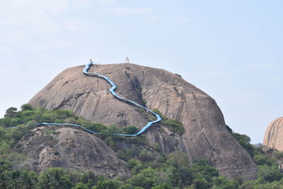 Low angle view of rock formation on mountain against sky