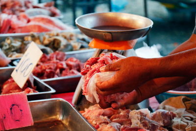 Midsection of man preparing food at market