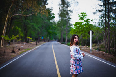 Full length of woman on road against trees