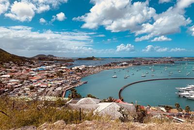 High angle view of city by sea against sky