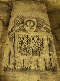 Low angle view of text on stone wall