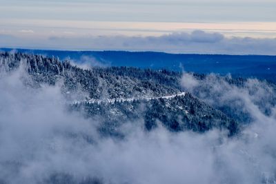 Aerial view of landscape in foggy weather against sky