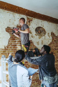 Female construction manager assisting workers in working at site