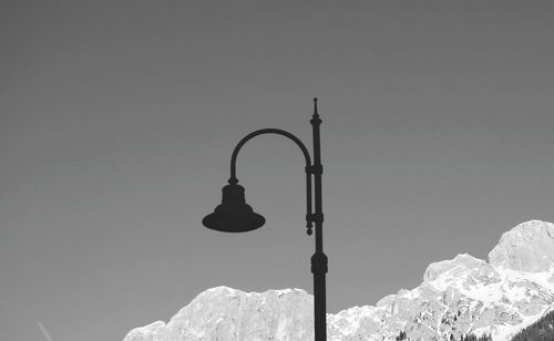 Low angle view of street light against clear sky mountain