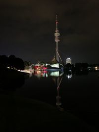 Reflection of illuminated tower in water at night