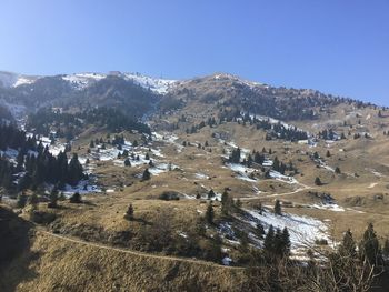 Scenic view of snowcapped mountains against clear blue sky