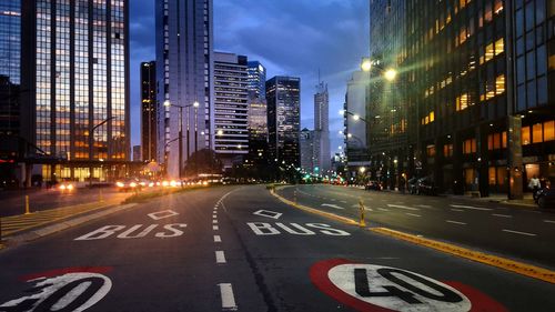 View of city street and buildings at night