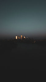 City buildings against clear sky at dusk