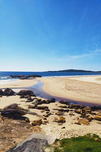 Scenic view of beach against blue sky