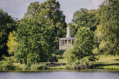 Trees by lake against sky