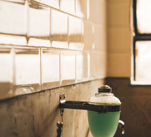 Close-up of soap dispenser on wall in bathroom