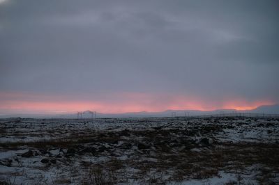 Snow covered landscape at sunset