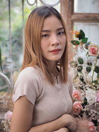 Portrait of beautiful woman with red flower