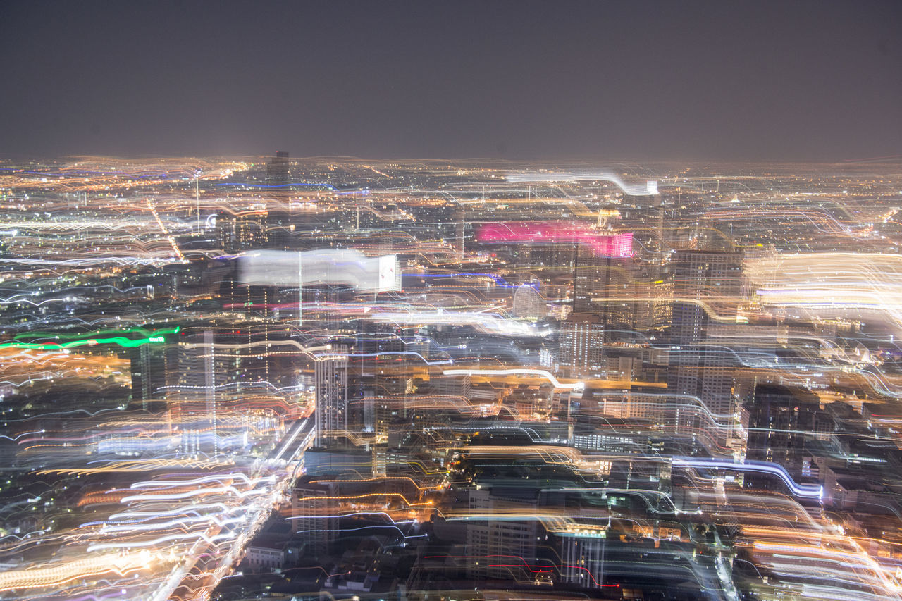 HIGH ANGLE VIEW OF ILLUMINATED CITY BUILDINGS AT NIGHT