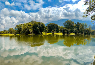 Scenic view of lake by trees against sky