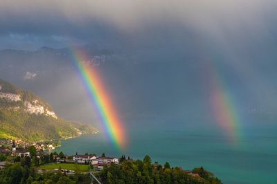 Scenic view of rainbow over mountain against sky