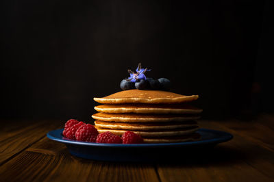 Close-up of cake on table against black background