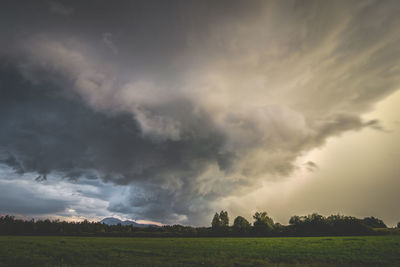 Scenic view of field against cloudy sky