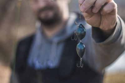 Midsection of man holding fishing tackle