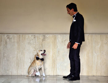 Full length of young couple standing with dog