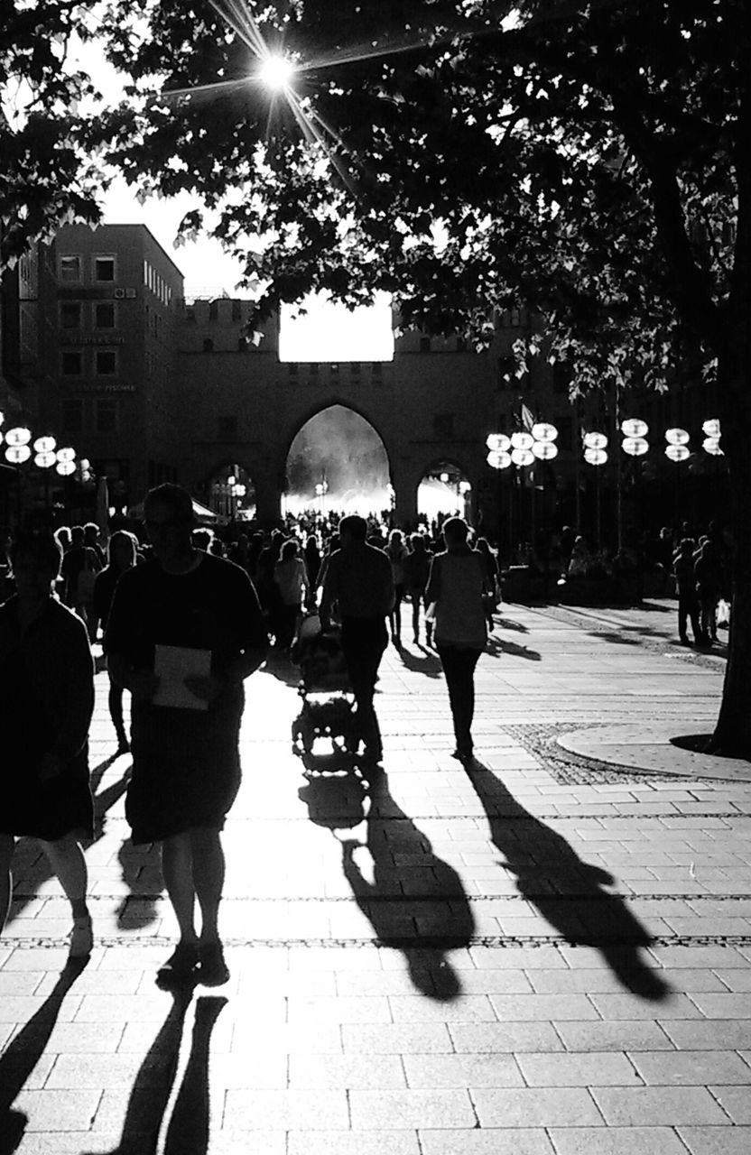 lifestyles, walking, architecture, person, men, built structure, building exterior, large group of people, leisure activity, city, city life, sunlight, tree, street, cobblestone, shadow, full length, footpath, rear view