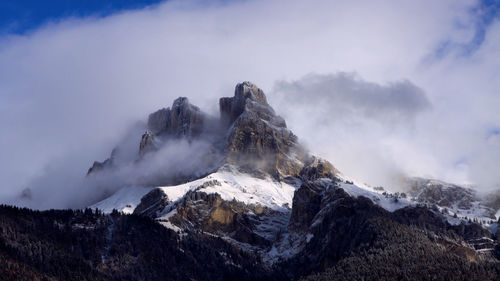 Blue sky and white clouds on snowy mountain peak in the french alps