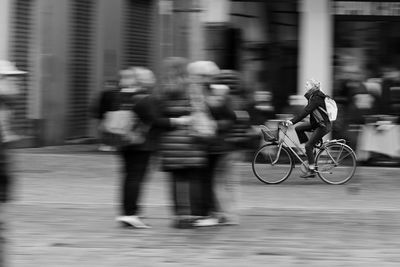 People riding bicycle on street in city