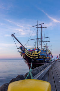 Sailboat moored on sea against sky