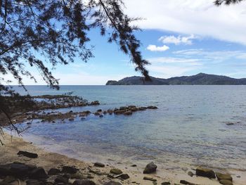Scenic view of sea and mountains against sky