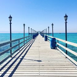 Pier on sea against blue sky