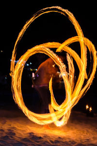 Blurred motion of woman dancing against sky at night