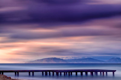 Scenic view of snow covered mountains against sky at sunset