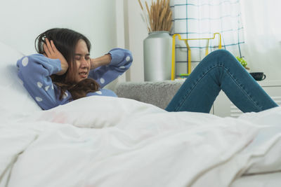 Woman lying on bed at home