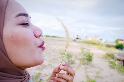 Beautiful hijab woman blowing grass