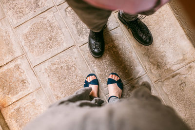 Low section of man standing on tiled floor