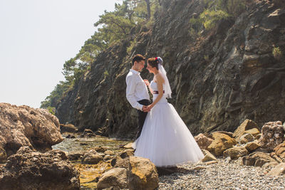 Young couple embracing while standing at beach