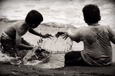 Boy in water splashing in front of beach