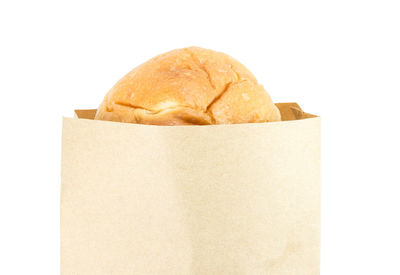 Close-up of bread in box against white background