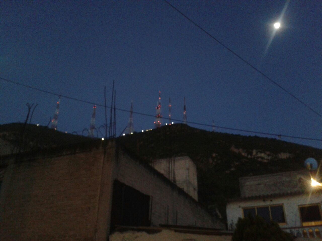 architecture, building exterior, built structure, low angle view, electricity, power line, illuminated, sky, cable, street light, night, house, electricity pylon, fuel and power generation, clear sky, power supply, lighting equipment, blue, residential structure, residential building