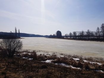 Scenic view of lake against sky during winter