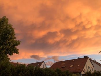 Houses and trees against sky during sunset