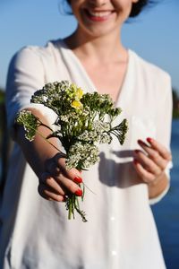 Midsection of woman holding flower