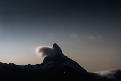 Scenic view of snowcapped mountain against sky at sunset