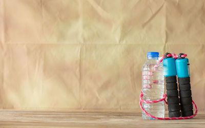 Glass of jar on table against wall