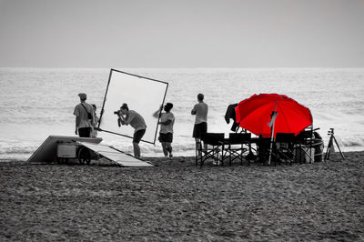 People at beach against sky