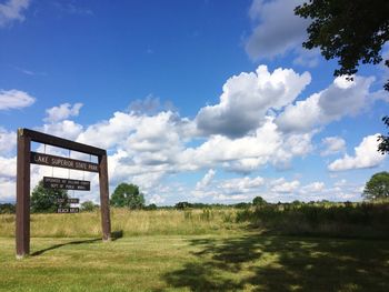 Sign board at lake superior state park against cloudy sky